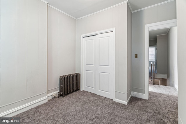 unfurnished bedroom featuring radiator, crown molding, and carpet