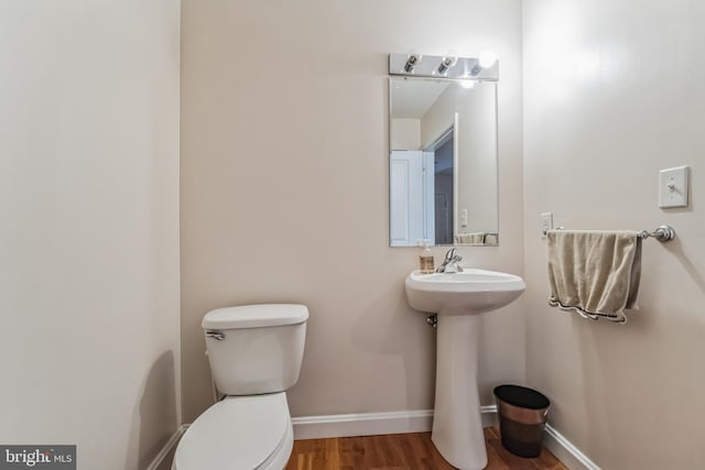 bathroom with toilet, sink, and hardwood / wood-style floors