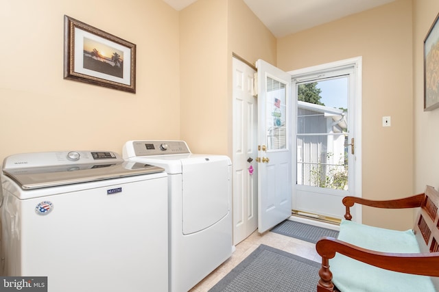 laundry area featuring light tile patterned floors, separate washer and dryer, and a healthy amount of sunlight