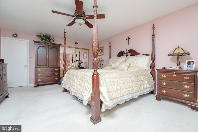 bedroom with a closet, ceiling fan, and light colored carpet