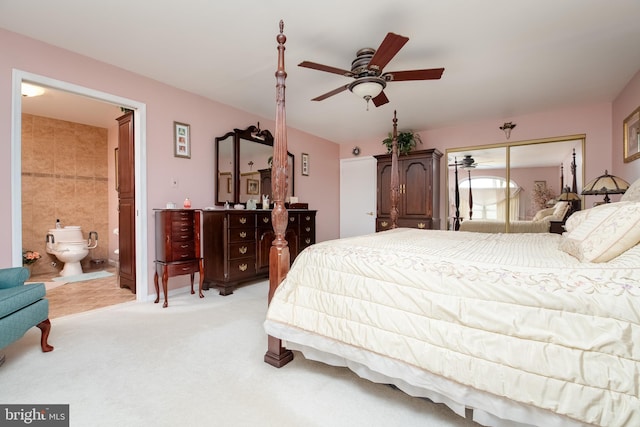 carpeted bedroom with ensuite bath, ceiling fan, and a closet