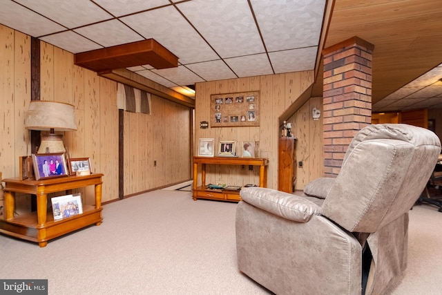 sitting room with ornate columns, light carpet, and wooden walls