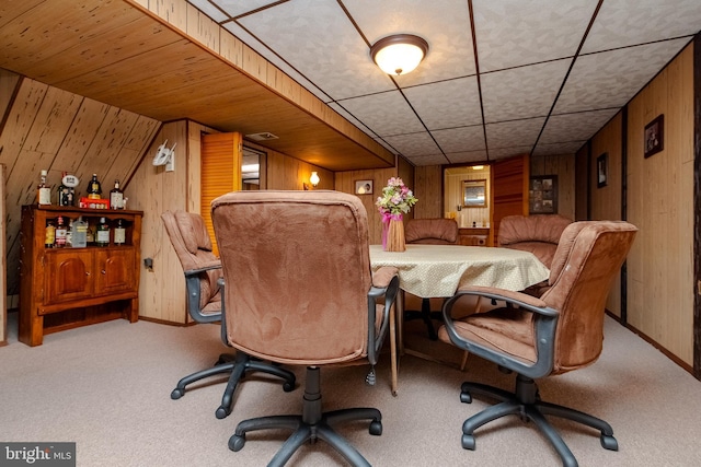 carpeted home office with wood walls