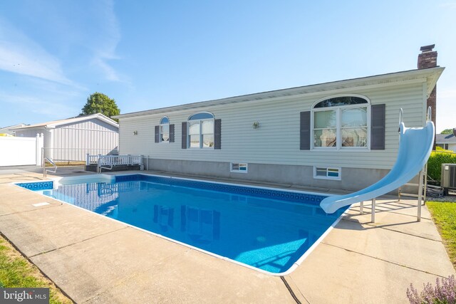 view of swimming pool with a patio and a water slide