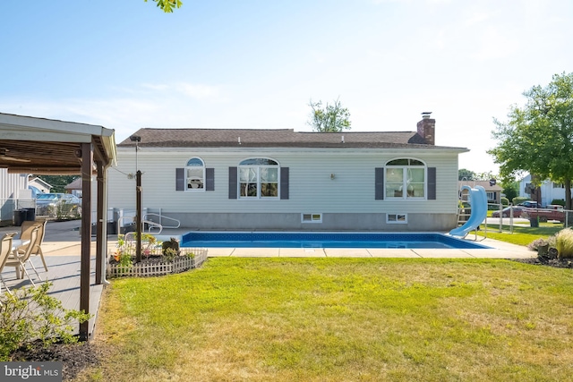 rear view of house with a lawn and a patio