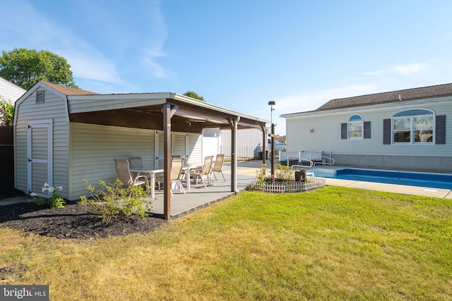 rear view of property with a lawn and an outdoor structure