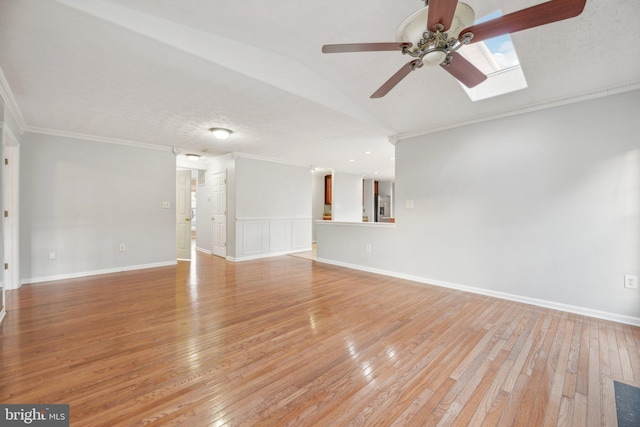 unfurnished living room featuring ceiling fan, ornamental molding, light hardwood / wood-style flooring, and a textured ceiling