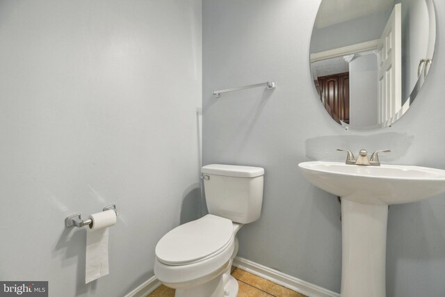 bathroom with toilet and tile patterned flooring