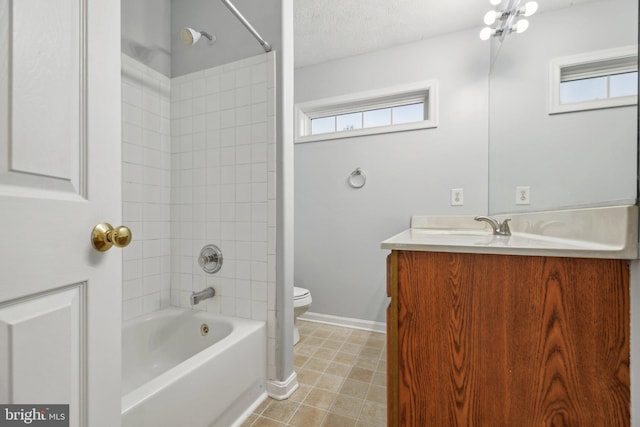 full bathroom with tiled shower / bath, vanity, toilet, and a wealth of natural light