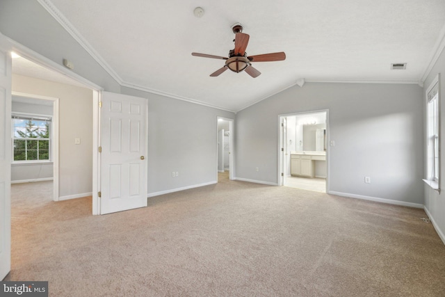 interior space with ceiling fan, ornamental molding, vaulted ceiling, and light carpet