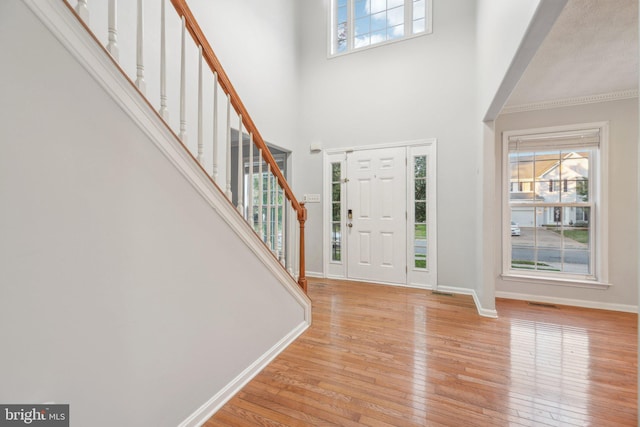 entrance foyer featuring a high ceiling, a wealth of natural light, and light hardwood / wood-style floors