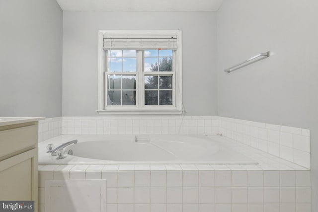 bathroom featuring vanity and tiled bath