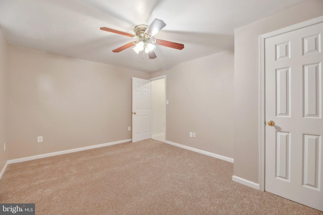 carpeted spare room with ceiling fan