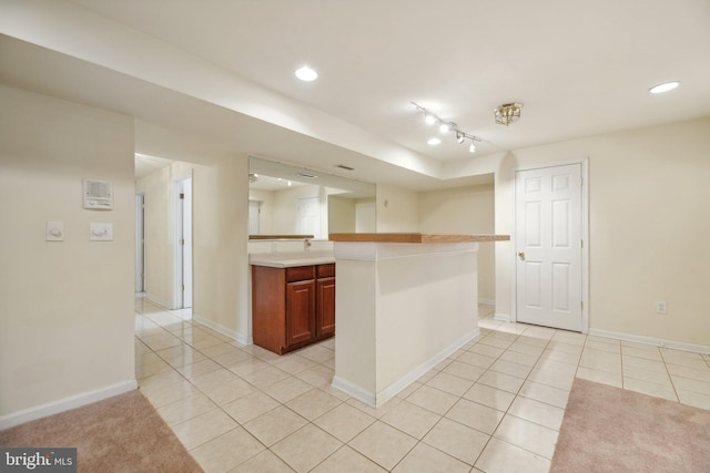 kitchen with light tile patterned flooring and kitchen peninsula