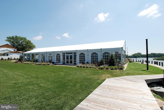 back of property featuring a yard, french doors, and a water view