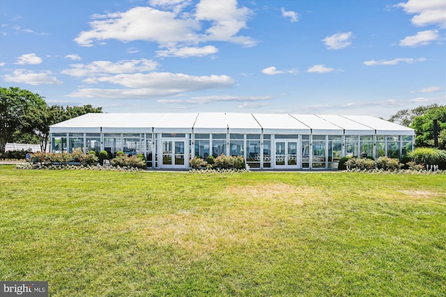 rear view of property featuring a lawn