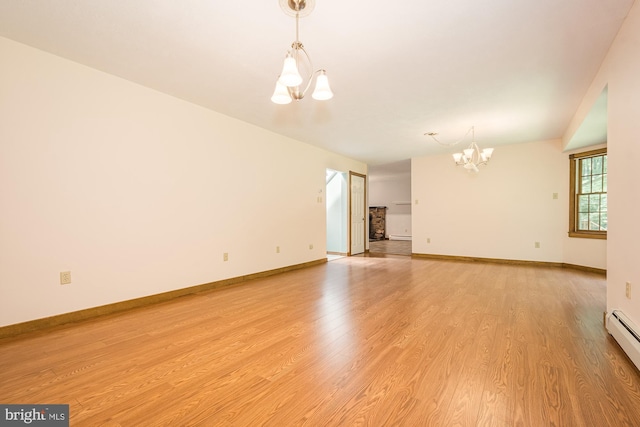 unfurnished living room with light wood-type flooring, a baseboard radiator, and a notable chandelier