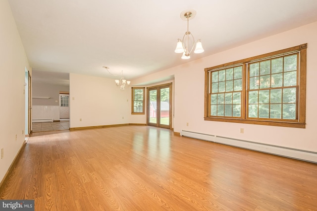 unfurnished room featuring baseboard heating, light wood-type flooring, and an inviting chandelier