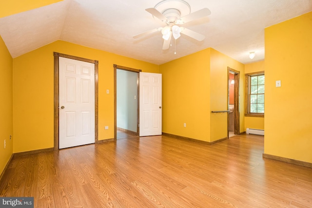 unfurnished bedroom featuring baseboard heating, light hardwood / wood-style flooring, ceiling fan, and lofted ceiling