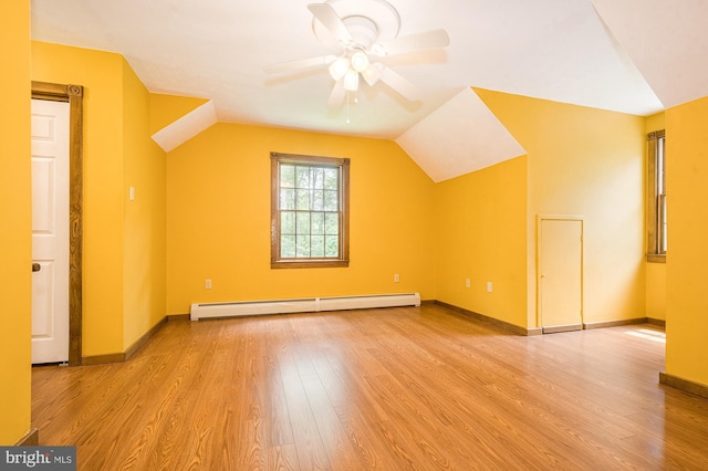 additional living space featuring baseboard heating, ceiling fan, light hardwood / wood-style floors, and lofted ceiling