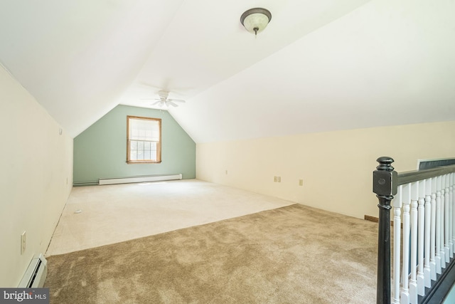 additional living space with baseboard heating, ceiling fan, light colored carpet, and vaulted ceiling