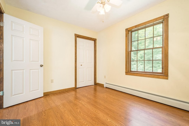 unfurnished bedroom with light hardwood / wood-style floors, baseboard heating, and ceiling fan