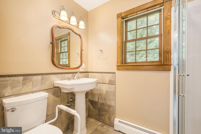 bathroom with tile patterned floors, toilet, tile walls, and a baseboard radiator