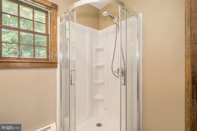 bathroom with an enclosed shower and a baseboard heating unit