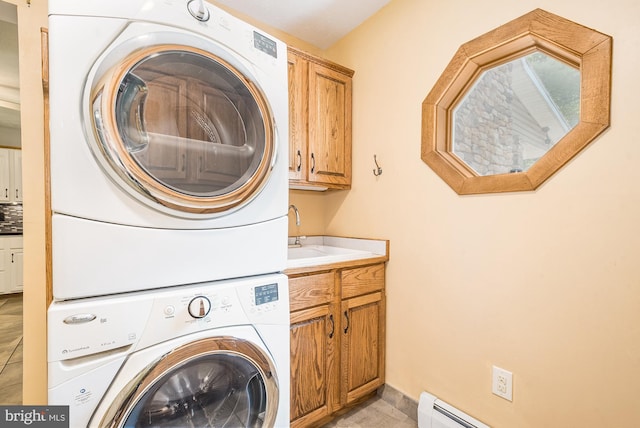 clothes washing area with cabinets, sink, light tile patterned floors, a baseboard radiator, and stacked washer / drying machine