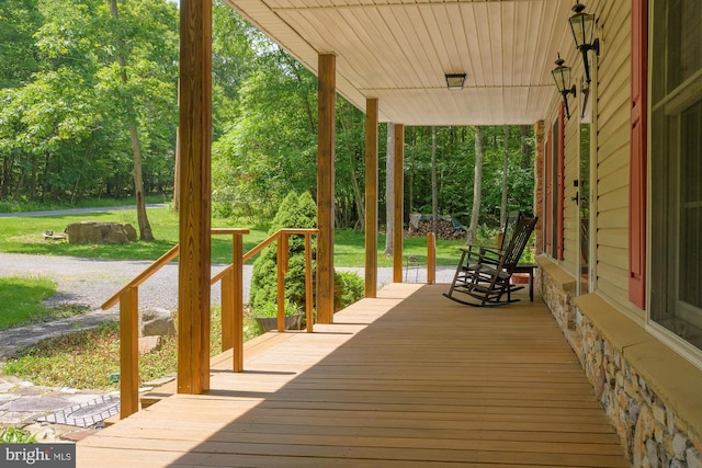 deck featuring a lawn and a porch