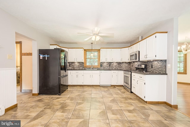 kitchen featuring white cabinets, ceiling fan with notable chandelier, sink, baseboard heating, and stainless steel appliances