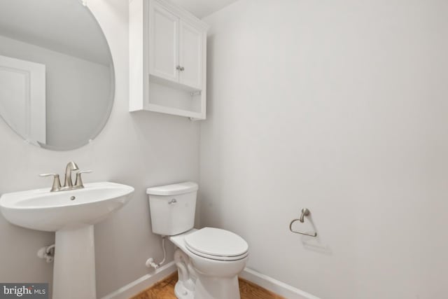 bathroom featuring hardwood / wood-style flooring, sink, and toilet