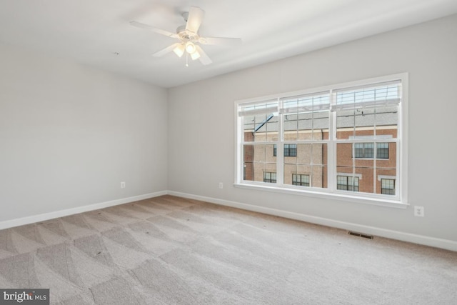 empty room with ceiling fan and light colored carpet