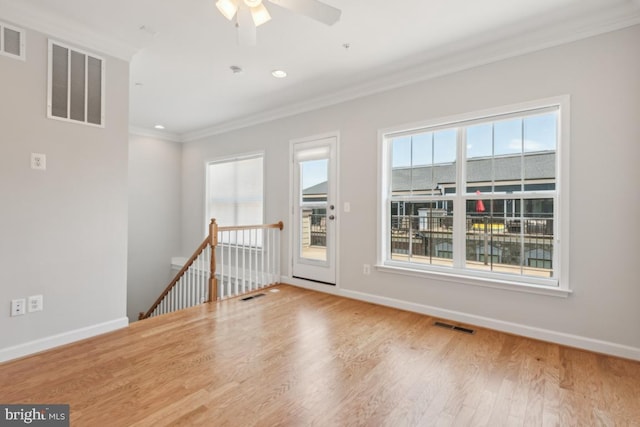 unfurnished room featuring ceiling fan, ornamental molding, a healthy amount of sunlight, and hardwood / wood-style floors