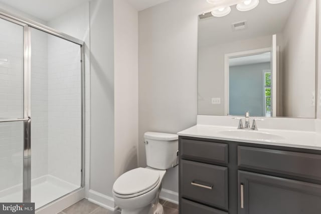 bathroom with toilet, tile patterned floors, a shower with shower door, and vanity