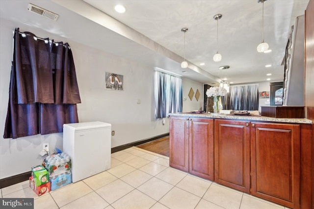 kitchen featuring a chandelier, decorative light fixtures, fridge, and light tile patterned flooring