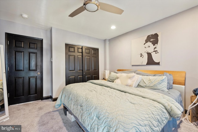 bedroom featuring light colored carpet, a closet, and ceiling fan