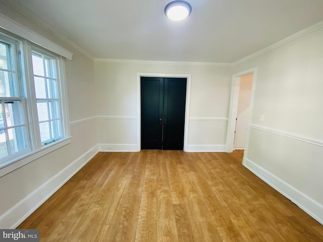 empty room featuring light hardwood / wood-style floors and ornamental molding