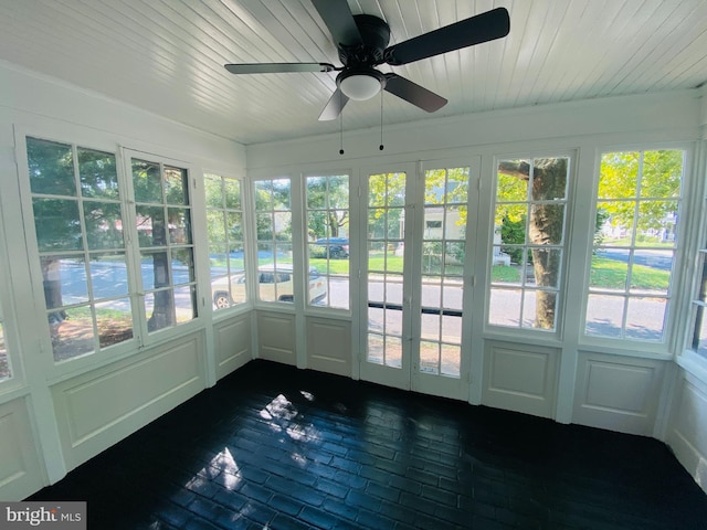 unfurnished sunroom with ceiling fan, wood ceiling, and a healthy amount of sunlight