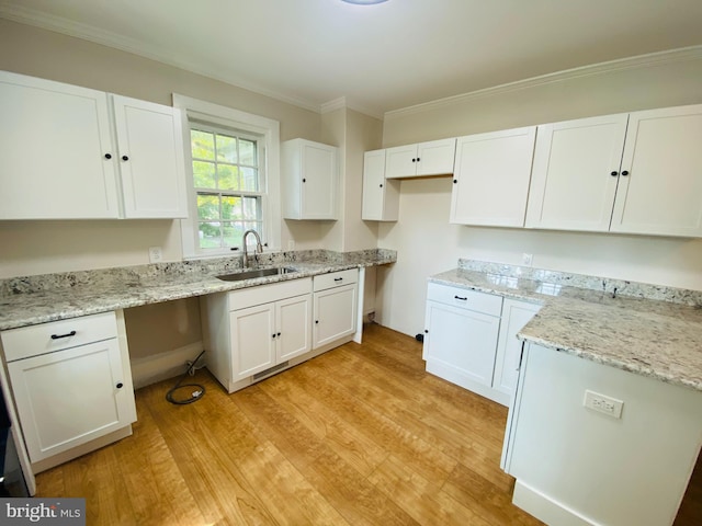 kitchen with white cabinets, light wood-type flooring, sink, and ornamental molding