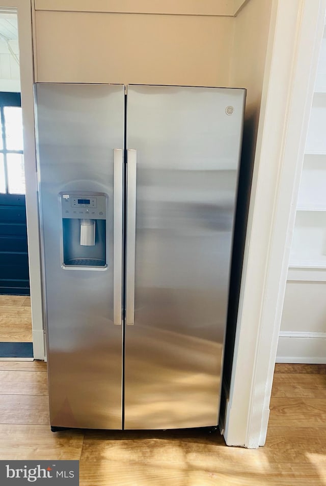 room details featuring stainless steel fridge and light wood-type flooring