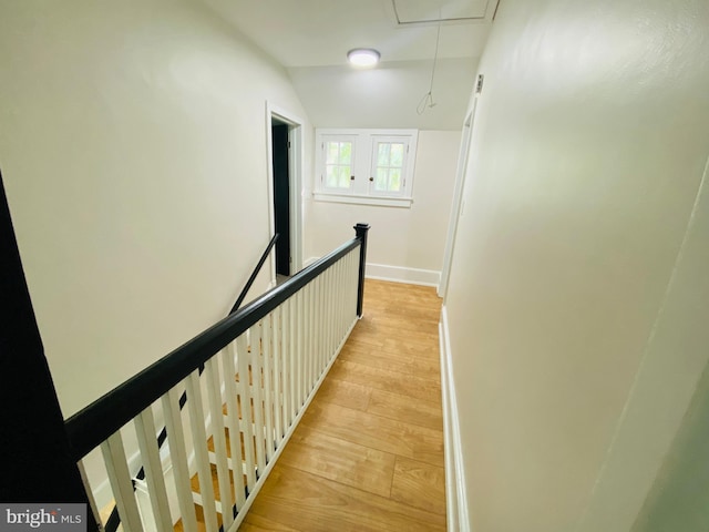 hallway with light hardwood / wood-style floors and vaulted ceiling