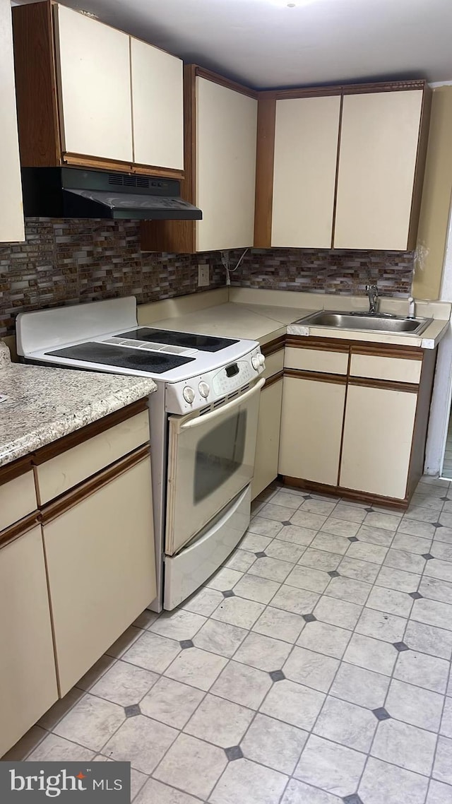 kitchen featuring decorative backsplash, sink, and white stove