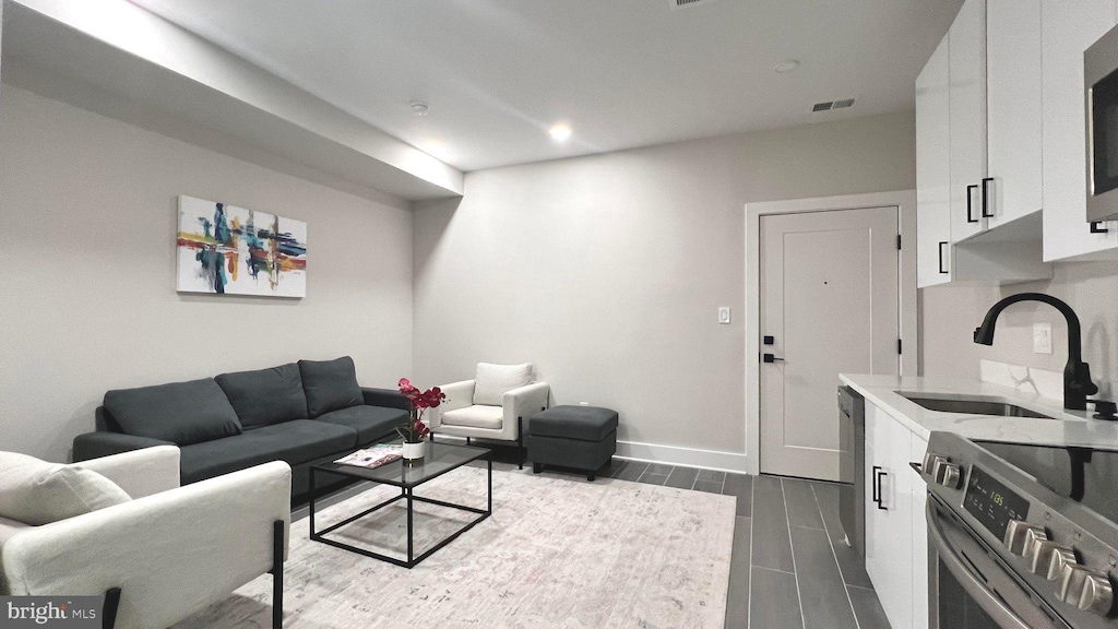 living area with visible vents, baseboards, and wood tiled floor