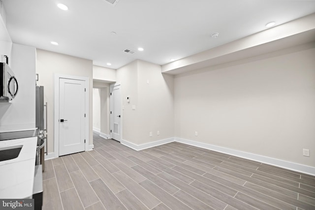 basement with baseboards, recessed lighting, visible vents, and wood tiled floor