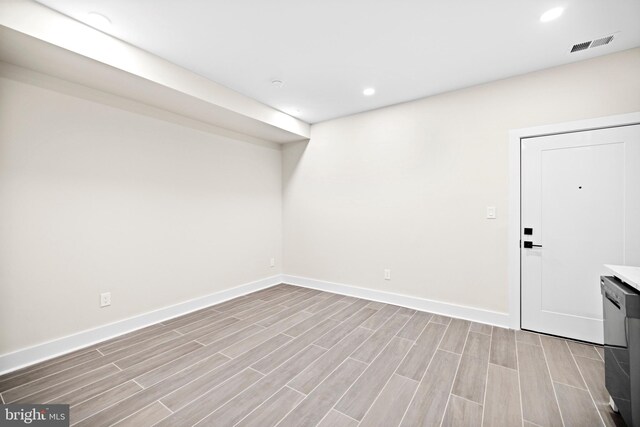 basement featuring wood finish floors, visible vents, baseboards, and recessed lighting