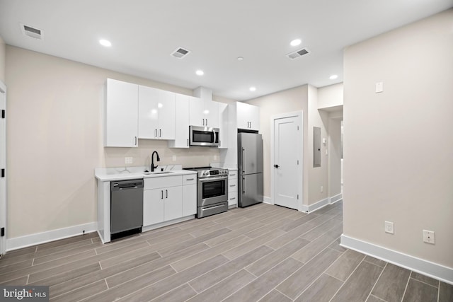 kitchen with visible vents, wood tiled floor, light countertops, appliances with stainless steel finishes, and a sink