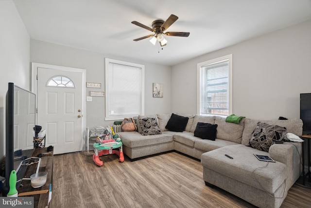 living room featuring hardwood / wood-style floors and ceiling fan