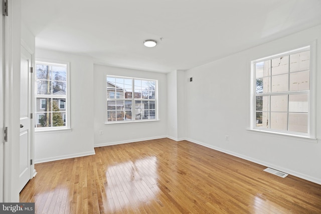 unfurnished room featuring a wealth of natural light and light hardwood / wood-style flooring