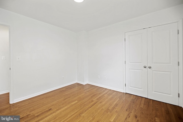 unfurnished bedroom with a closet and hardwood / wood-style flooring